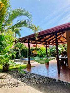 a pavilion with a hammock hanging from it at La Mona Beach House in Jacó