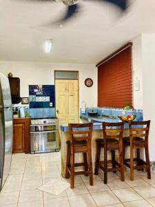 cocina con mesa, 4 sillas y fogones en La Mona Beach House, en Jacó