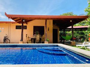 een zwembad voor een huis met een paviljoen bij La Mona Beach House in Jacó