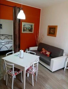 sala de estar con mesa blanca y sofá en Amocasa en Ragusa
