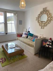 sala de estar con sofá y espejo en Apartment in Old Town near the beach en Hastings