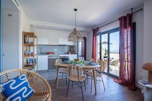 eine Küche und ein Esszimmer mit einem Tisch und Stühlen in der Unterkunft Heima in front of the Sea in Málaga