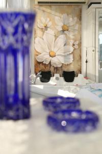 a table with blue plates and a painting of flowers at Dantela Butik Hotel in Cesme