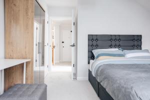 una camera con un grande letto con testiera nera di Luxury central apartment sleeps 7 guests with free parking and Netflix a Bournemouth