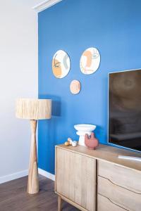 ein Wohnzimmer mit einem TV und einer blauen Wand in der Unterkunft Heima in front of the Sea in Málaga