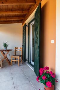 un patio con porta, sedia e fiori di Julia΄s Apartment a Città di Corfù