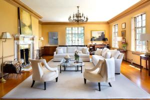 sala de estar con muebles blancos y chimenea en Winthrop Estate 12K SF 32 Acres, en Lenox