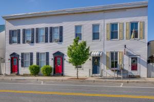 una casa blanca con puertas rojas en una calle en Cozy Maryland Abode - Gas Grill, Near Devils Den!, en Emmitsburg