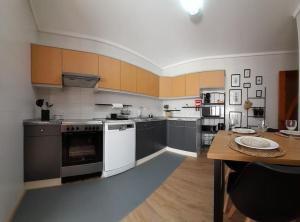 a kitchen with white appliances and a wooden table at Mar Doce Lar- Entre Mar e Ria in Gafanha da Nazaré +4 photos