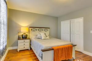 1 dormitorio con cama y mesita de noche con lámpara en Cozy Maryland Abode - Gas Grill, Near Devils Den!, en Emmitsburg