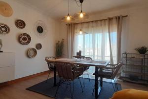 a dining room with a table and chairs and a window at Mar Doce Lar- Entre Mar e Ria in Gafanha da Nazaré