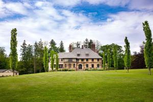 Winthrop Estate 12K SF 32 Acres في لينوكس: منزل كبير على حقل أخضر مع أشجار