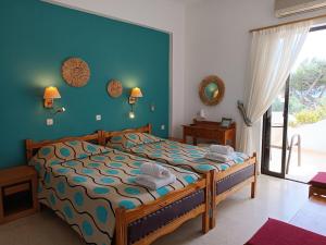 een slaapkamer met een bed met een blauwe muur bij Castello Verde Apartments Studios in Plakias