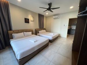 a bedroom with two beds and a ceiling fan at Nice Podium View @Atlantis Melaka in Melaka
