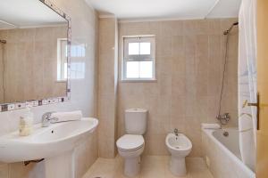 a bathroom with a sink and a toilet and a tub at Algarve apartments L in Olhos de Água +16 photos
