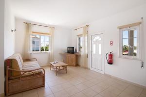 a living room with a couch and a chair and windows at Algarve apartments L in Olhos de Água