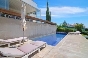 einen Pool mit 2 Liegestühlen und einem Sonnenschirm in der Unterkunft Sweet Home Albufeira in Albufeira
