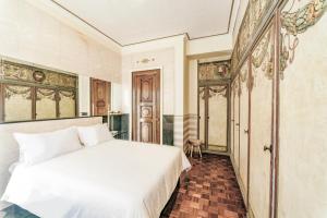 a bedroom with a white bed in a room at Rivière Private Rooms Alla Scala in Milan
