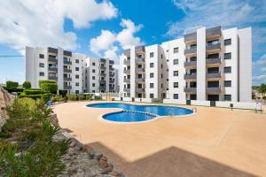 un complejo de apartamentos con piscina frente a un edificio en Apartamento Los Alcores, en San Miguel de Salinas