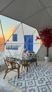 a living room with a table and chairs in a tent at Bubbles Domes Private Cmp in Al Wāşil