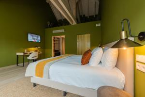 a bedroom with a large bed with green walls at Silken Puerta de Irati in Ochagavía