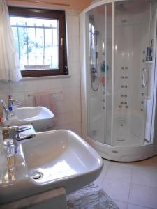 een witte badkamer met een wastafel en een douche bij Villa Campo dei Fiori in Casciago