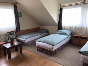 a attic room with two beds and a table at Luca Apartman in Esztergom