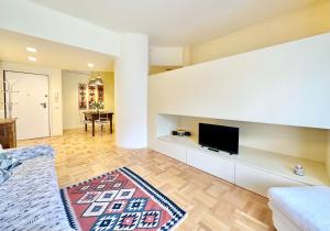 un soggiorno con una TV a schermo piatto su una parete di Hostdomus - Casa Corallo ad Alassio