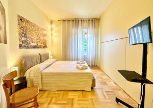 Dormitorio pequeño con cama y TV en Hostdomus - Casa Corallo, en Alassio
