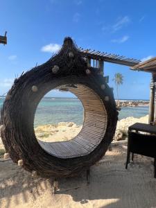 Una gran hamaca tejida en una playa con el océano. en Le NIL, en Sainte-Anne
