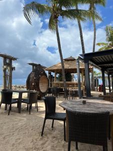 una playa con mesas, sillas y palmeras en Le NIL, en Sainte-Anne