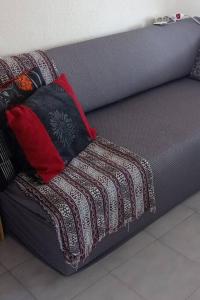a couch with two pillows on top of it at Sophie's Summer House in Nea Fokea