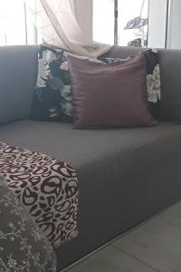a couch with several pillows on top of it at Sophie's Summer House in Nea Fokea