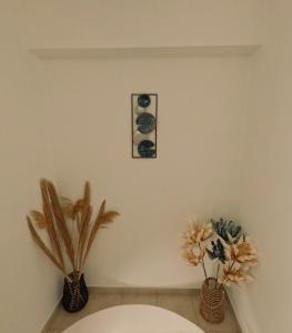 a bathroom with two vases with flowers on a wall at George Seaside House Makry Gialos in Makry Gialos