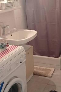 a bathroom with a sink and a washing machine at Sophie's Summer House in Nea Fokea