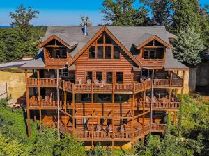 a large wooden house with a large deck at Serenity Mountain Pool Lodge in Sevierville