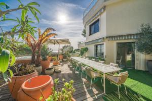 a wooden deck with a long table and chairs at Luxury Villa with SPA in Golfe-Juan - Sea View in Vallauris