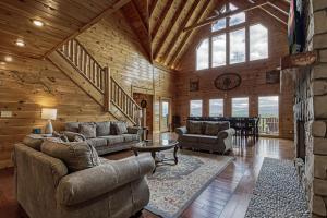una sala de estar con sofás y una escalera en una cabaña en Serenity Mountain Pool Lodge, en Sevierville