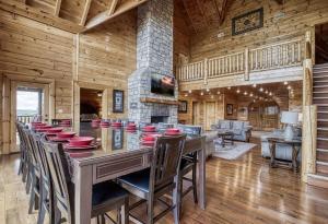 a dining room with a table and chairs and a fireplace at Serenity Mountain Pool Lodge in Sevierville