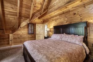 a bedroom with a bed in a log cabin at Serenity Mountain Pool Lodge in Sevierville