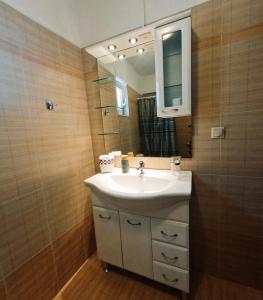 a bathroom with a sink and a mirror at George Seaside House Makry Gialos in Makry Gialos