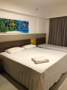 duże białe łóżko z 2 poduszkami w obiekcie Apartamento, Hotel Enjoy Park Resort w mieście Olímpia