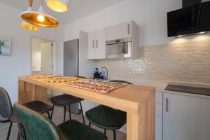 una cocina con una larga mesa de madera con sillas en Sabbia Suites My Place, en La Santa