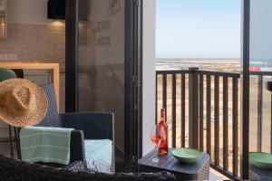 un balcón con una mesa y una copa de vino en Sabbia Suites My Place, en La Santa