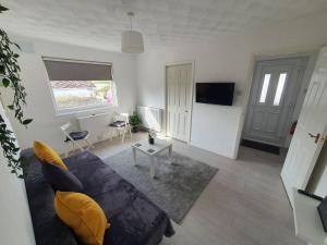 a living room with a couch and a table at Awave From It All - Escape the city life in Jaywick Sands