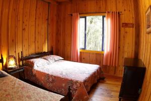 a bedroom with two beds and a window at Chalé Morada Alma Gêmea in Campo Alegre