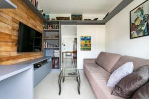 Il comprend un salon doté d'un canapé et d'une télévision à écran plat. dans l'établissement Duplex vista para o mar na praia dos Açores, à Florianópolis