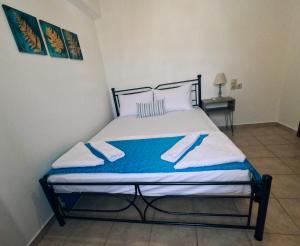 a bed in a room with two towels on it at George Seaside House Makry Gialos in Pilalímata