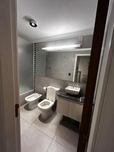 y baño con aseo, lavabo y espejo. en Opera Luxury Condominium en Córdoba