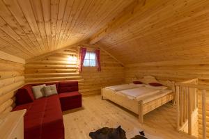 Blockhausschlafzimmer mit einem Bett und einem Sofa in der Unterkunft Anewandterhof in Bruneck